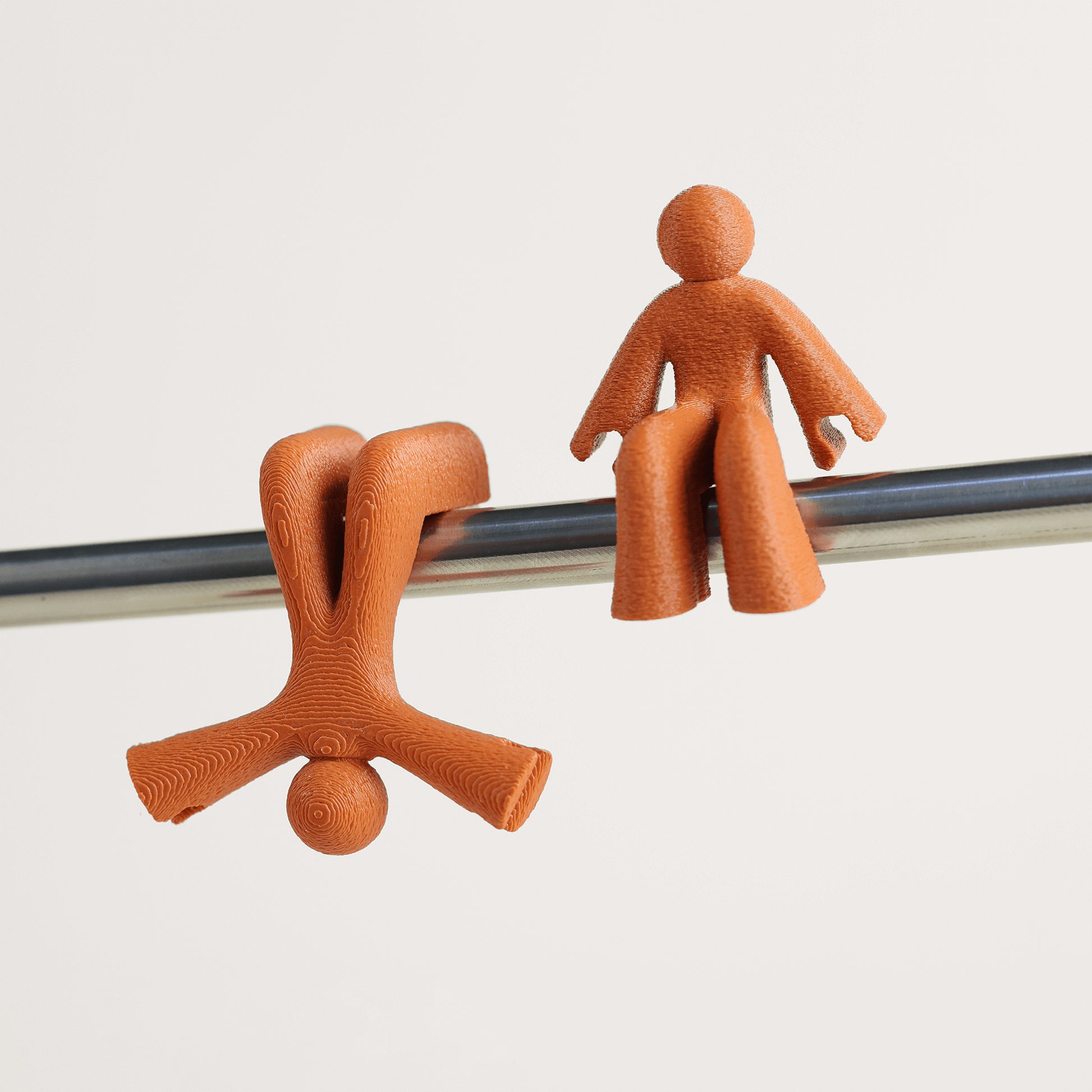 Two caramel brown character cable holders on a white background