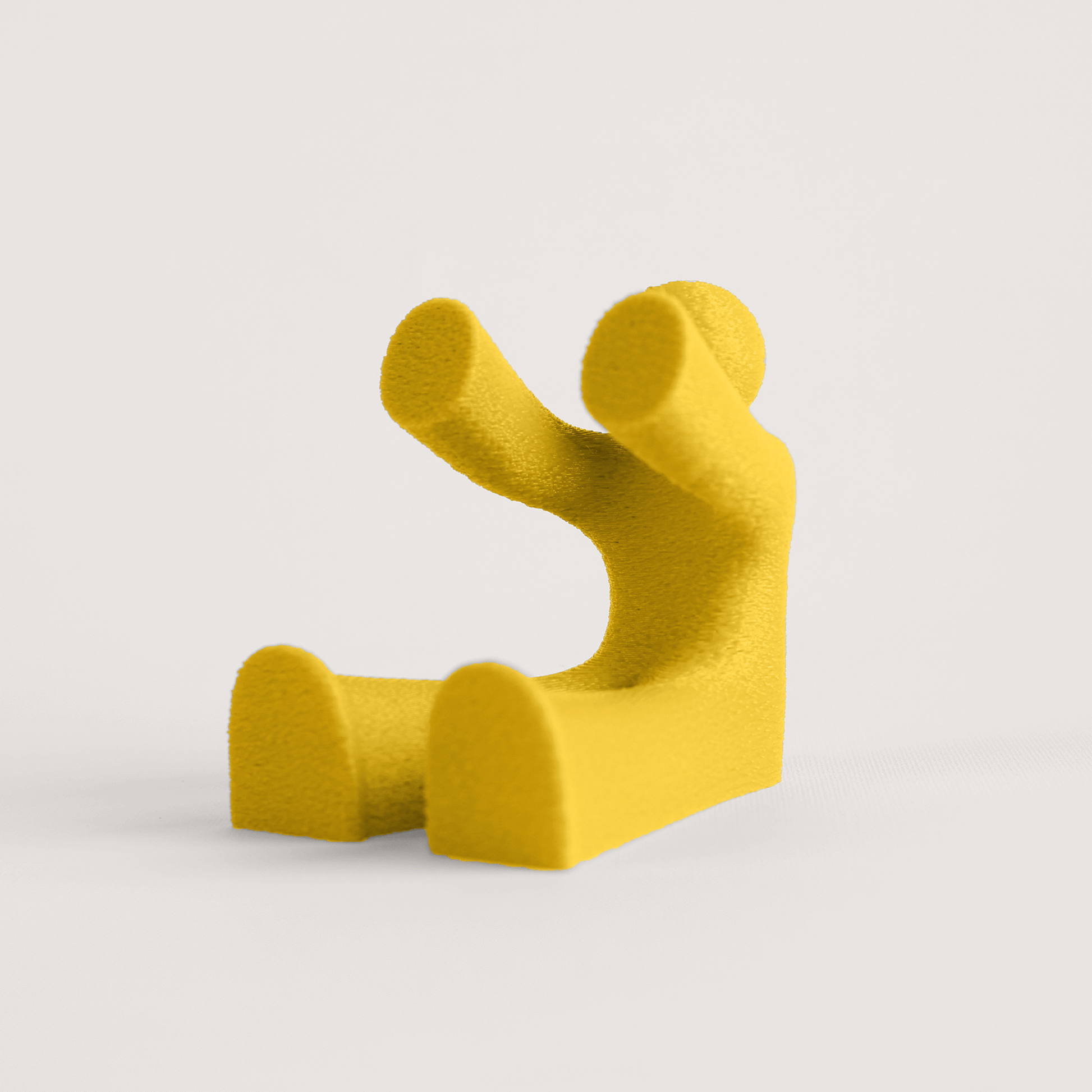 Yellow abstract seated character that acts as a phone holder